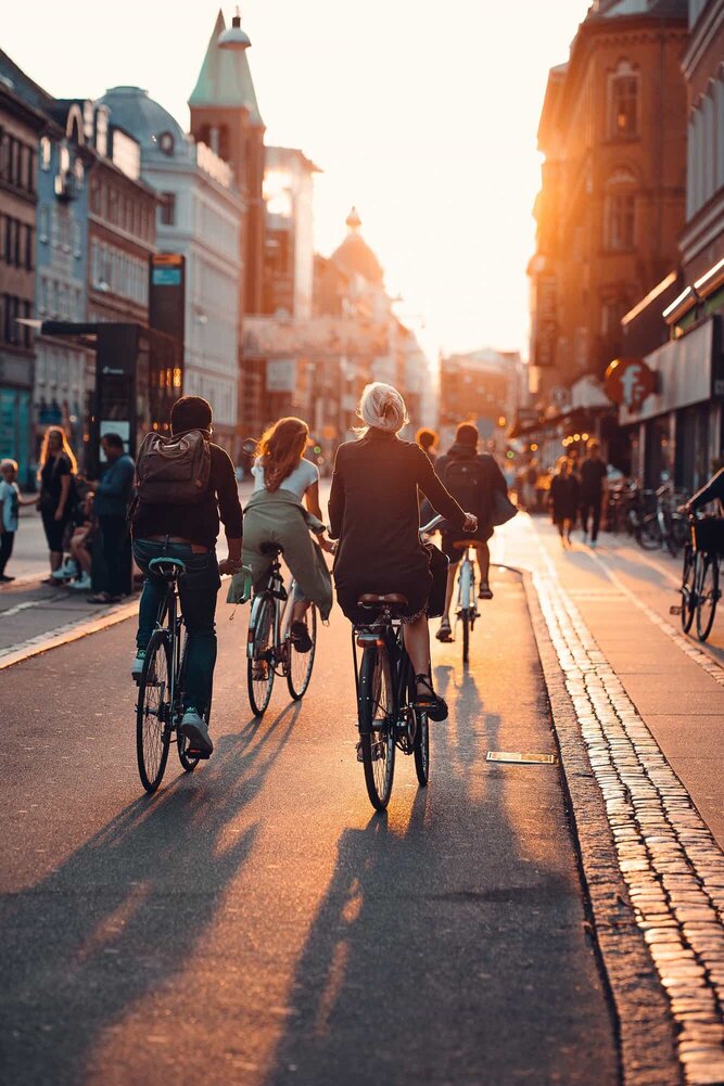 En masse cyklister der cykler på en gade i København.